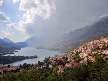 Scenic view of townscape by mountains against sky