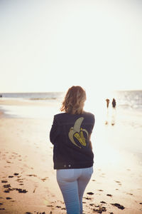 Rear view of woman looking at sea against clear sky