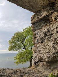 Rock formation by sea against sky