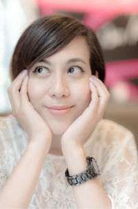 Close-up of smiling thoughtful woman wearing wristwatch