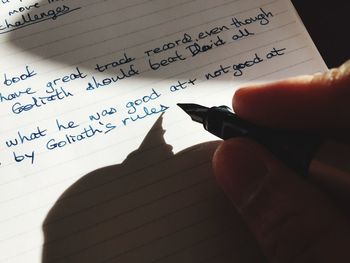 Midsection of person with text on paper