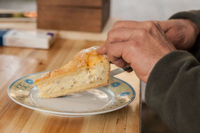 Close-up of man holding ice cream on table