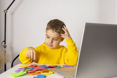 Adorable, cute, little boy learning alphabet online, with laptop at home. child using e-learning 