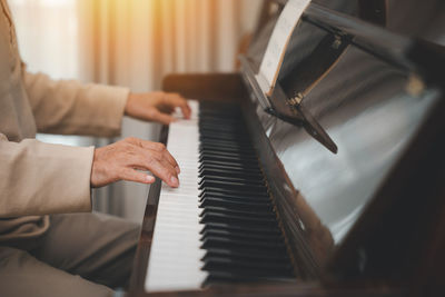 Midsection of woman playing piano