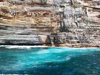 Scenic view of sea against cliff face 
