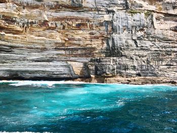 Scenic view of sea against cliff face 