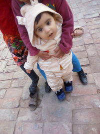 High angle portrait of cute baby girl on footpath