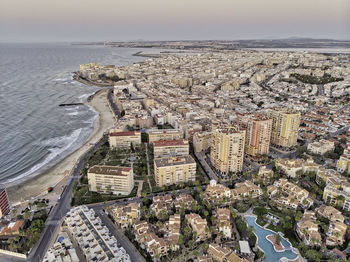 High angle view of buildings by sea against sky