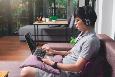 Man wearing headphone talking on video conference at home