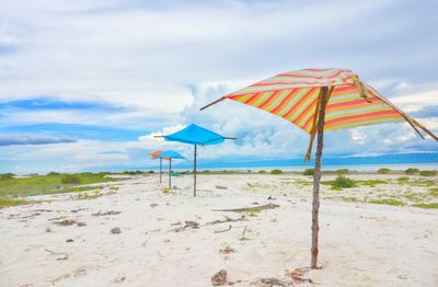 Umbrella on beach against sky