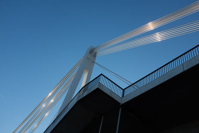 Low angle view of illuminated bridge against clear blue sky
