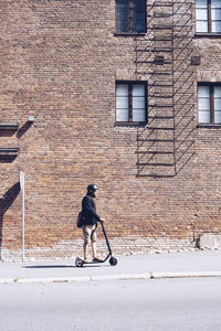 Man riding electric scooter on pavement