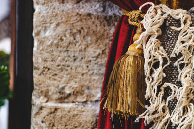 Close-up of tied hanging on rope against wall