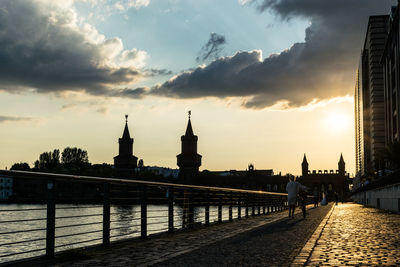 View of river in city against cloudy sky