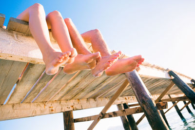 Low section of person on sea against clear sky