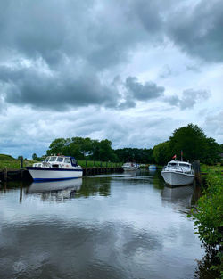 Boats moored in river against sky