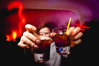 Man holding drink while standing in pub