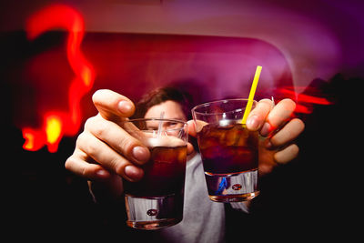 Close-up of hand holding cocktail glasses