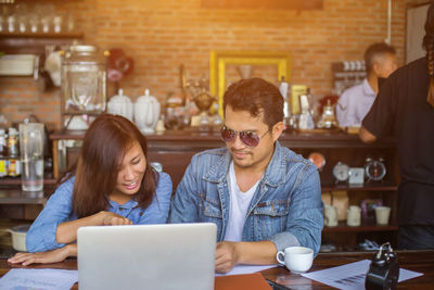 Young couple sitting on table at home