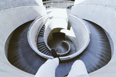 Low section of man against spiral staircase