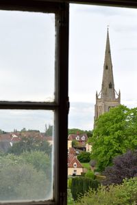 Buildings against sky seen through window