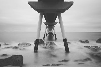 Low angle view of rocks in sea against sky