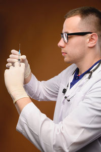 Midsection of man holding eyeglasses while standing