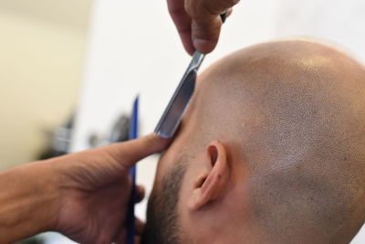 Close-up of hands cutting customer hair at salon