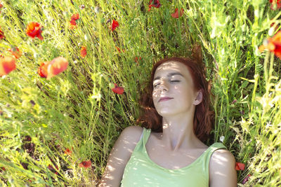 Portrait of young woman sitting on field