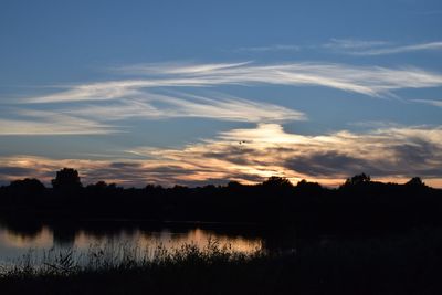 Scenic view of lake against sky at sunset