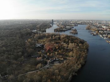 High angle view of river amidst buildings in town against sky