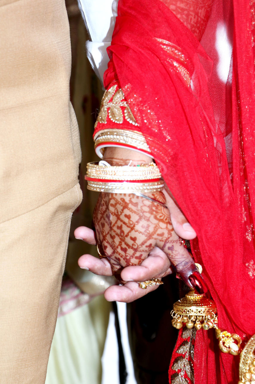 MIDSECTION OF WOMAN WITH RED MASK AGAINST BLURRED BACKGROUND