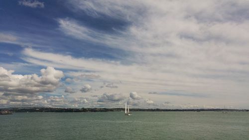 Sailboats sailing in sea against sky