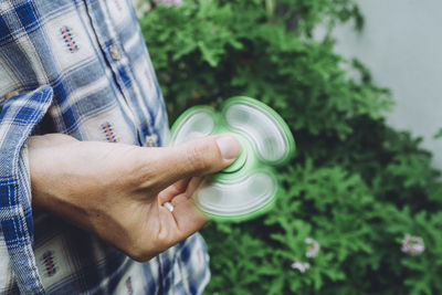 Midsection of man spinning fidget spinner