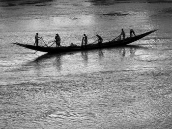 Silhouette people on boat in sea