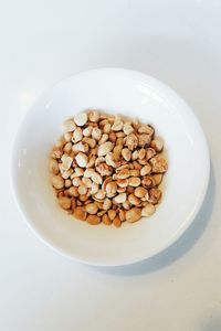 Close-up of coffee beans in bowl against white background