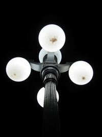 Low angle view of illuminated light bulb against sky