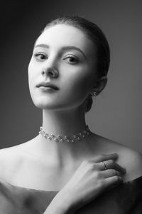 Portrait of beautiful young woman against gray background