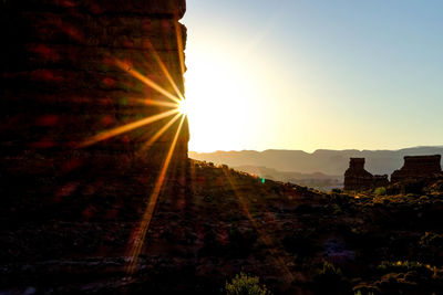 Sunlight streaming through old ruin against sky