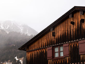 House on snowcapped mountain against sky