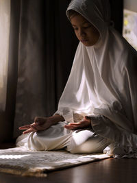 Full length of girl sitting at home