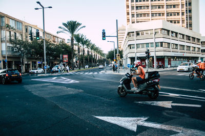 People riding motorcycle on city street