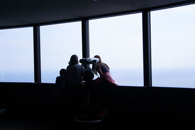 Tourists looking sky through observation point