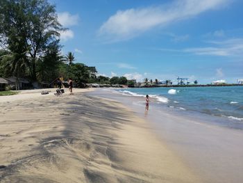 People on beach against sky