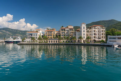 Buildings by sea against sky