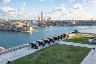 Scenic view of harbor by river against sky