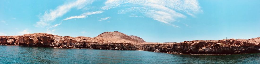 Scenic view of sea and mountains against sky