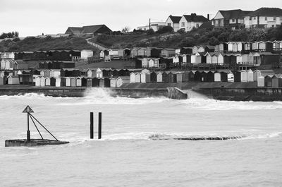 Buildings by sea against sky