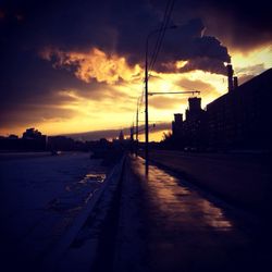 View of road against cloudy sky at sunset