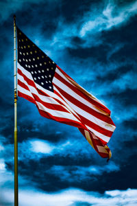 Low angle view of american flag against cloudy sky